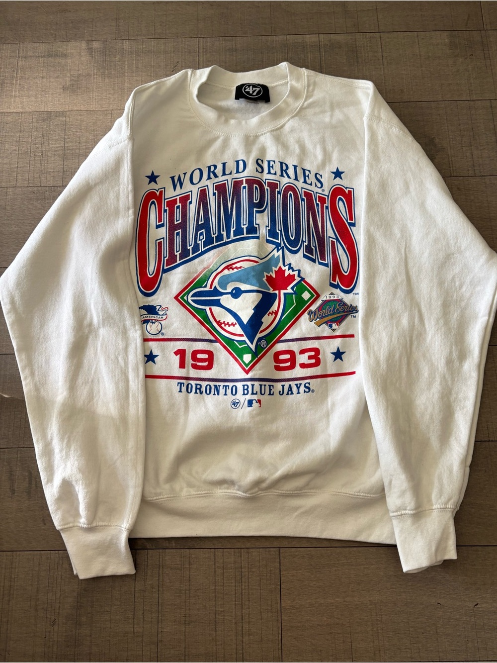 47 White Crewneck Sweatshirt with Red, Blue and Green Toronto Blue Jays Graphic